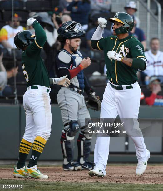 Tony Kemp of the Oakland Athletics congratulates teammate Edwin Diaz as he crosses home plate after hitting a two-run home run in the eighth inning...