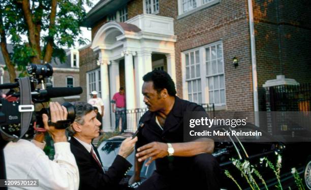 Reverend Jesse Jackson being interviewed by TV reporter in front of his home in LeDroit Park section of DC Washington DC, May, 1992