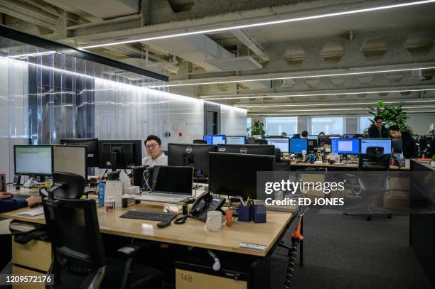 In a photo taken on April 9, 2020 employees at their desks beside empty spaces as part of proctective measures against the spead of the COVID-19...