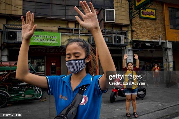 Catholic devotees pray outside a closed church, defying government orders to avoid religious gatherings and stay home to curb the spread of the...