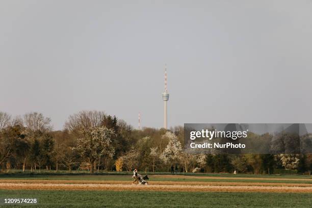 People walk during the afternoon sunset in Stuttgart, Germany on April 9, 2020