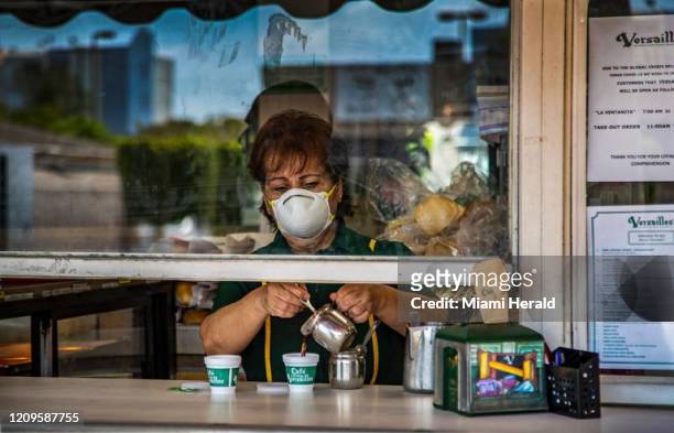 Nina Porras sirve un café con una máscara protectora en el rostro en la ventanita del popular restaurante Versailles durante la pandemia del...