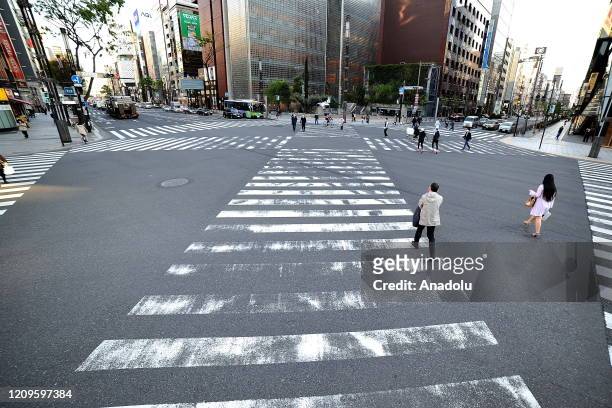 Few people are seen in a nearly empty street after the state of emergency declared to prevent the spread of coronavirus in Tokyo, Japan on April 10,...