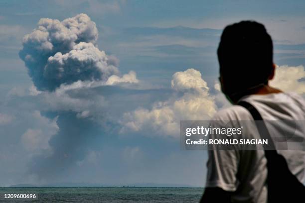 Man watches Krakatau spewing ash during an eruption, in Serang, Indonesia's Banten province on April 11, 2020.