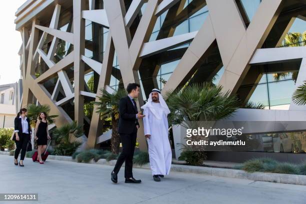 business people walking in the financial street - dubai people stock pictures, royalty-free photos & images