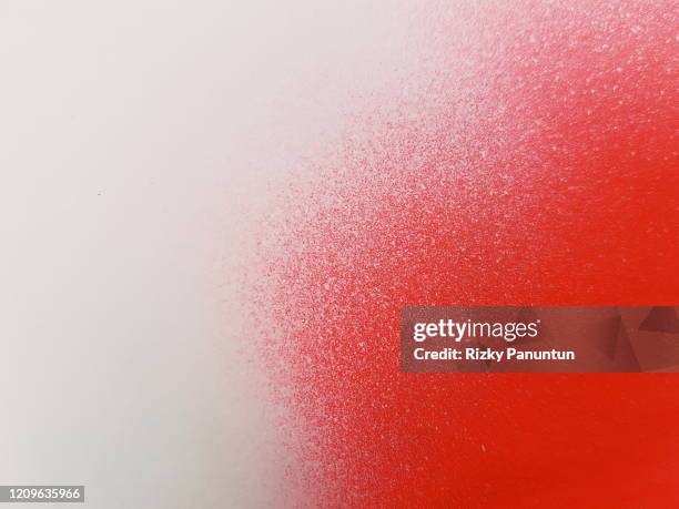 full frame of grey spray paint on red background - spotted foto e immagini stock