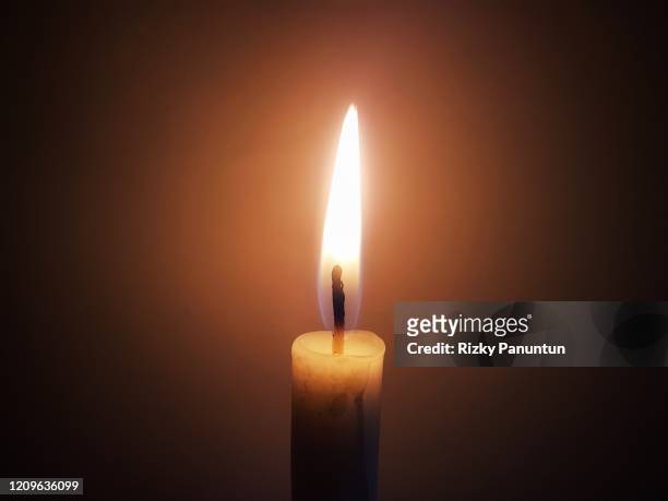 close-up of illuminated candle against dark background - candle flame stockfoto's en -beelden