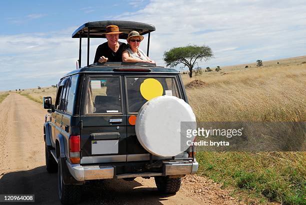 senior couple on jeep safari in serengeti,national park,tanzania - serengeti park stockfoto's en -beelden