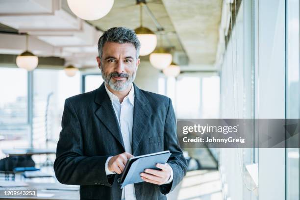 rijpe zakenman die digitale tablet in bureau gebruikt - 45 49 jaar stockfoto's en -beelden