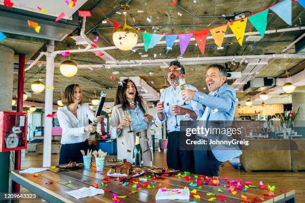 leuke zakenpartners die verjaardag met confetti vieren - party popper stockfoto's en -beelden