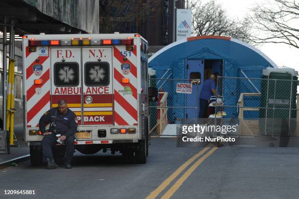 An ambulance driver waits outside the entrance to the makeshift COVID19 facility outside Mount Sinai Hospital in uptown Manhattan, New York City, on...