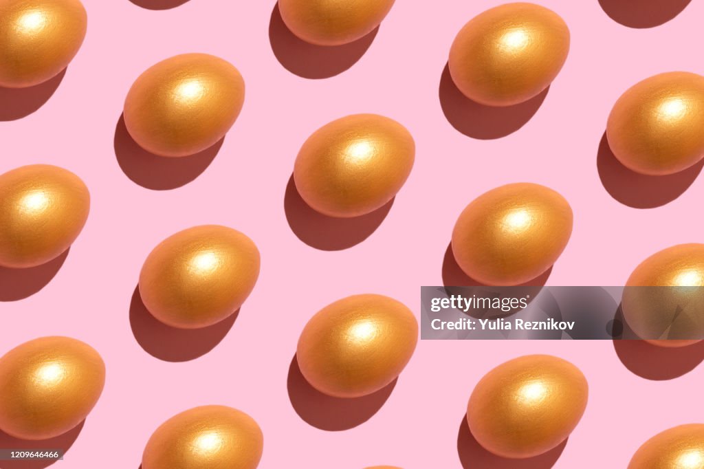 Golden eggs on the pink background