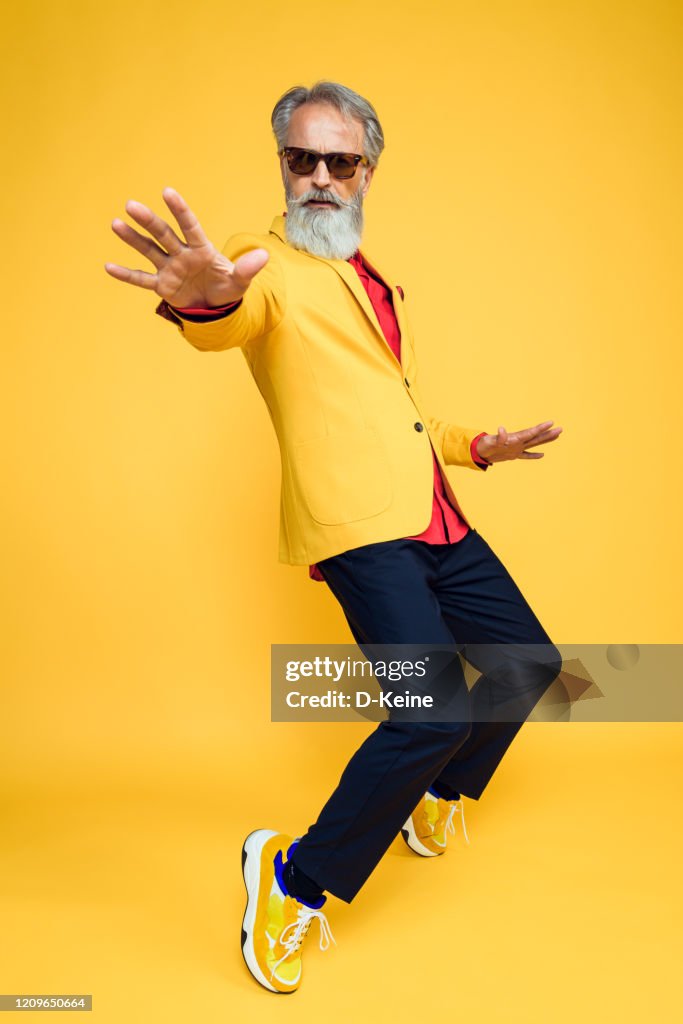 Happy well dressed gentleman having photoshooting in studio