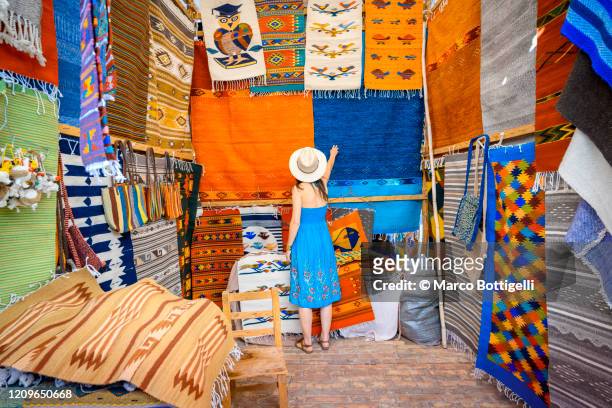 woman admiring the handmade rugs in oaxaca valley, mexico - souvenir bildbanksfoton och bilder