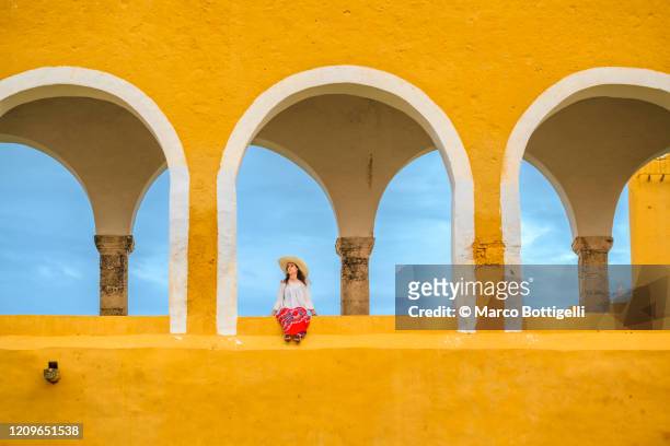 woman sitting outside the izamal monastery, yucatan peninsula, mexico - yucatan peninsula - fotografias e filmes do acervo