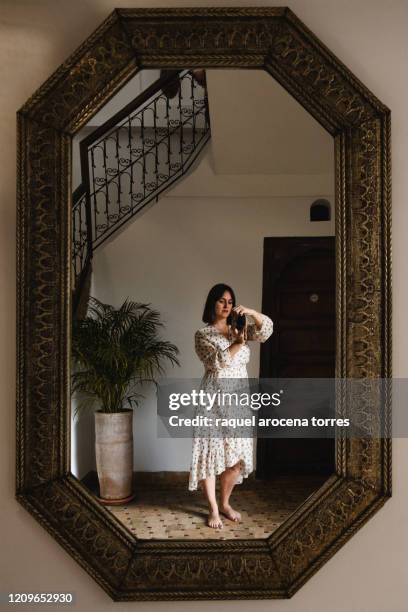 young woman self portrait in a wooden mirror with a white dress - morocco interior ストックフォトと画像