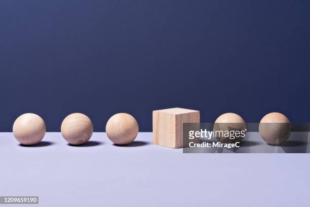 cube in a row of spheres - exclusion concept stock pictures, royalty-free photos & images