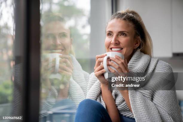 donna premurosa che beve una tazza di caffè a casa - cold temperature foto e immagini stock