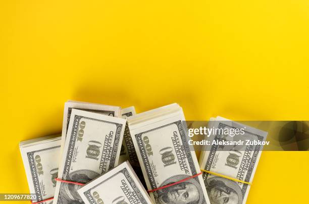 us dollars american bills in bundles on a bright yellow background. - coin stack stock-fotos und bilder