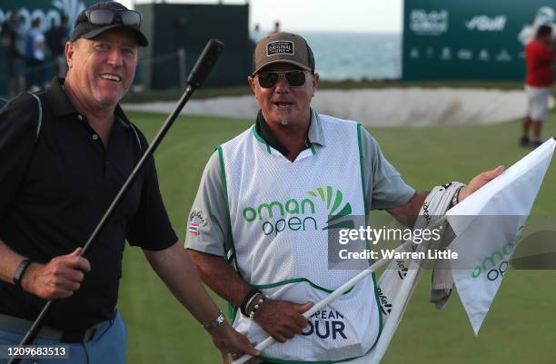 Kyle Roadley, caddie to the victorious Sami Valimaki of Finland is handed the the 18th green flag pin by Brian NIlsson , caddie of Nicolas Colsaerts...