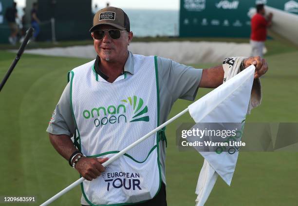 Kyle Roadley, caddie to the victorious Sami Valimaki of Finland removes the 18th green flag pin to keep as winning caddie during the final round of...