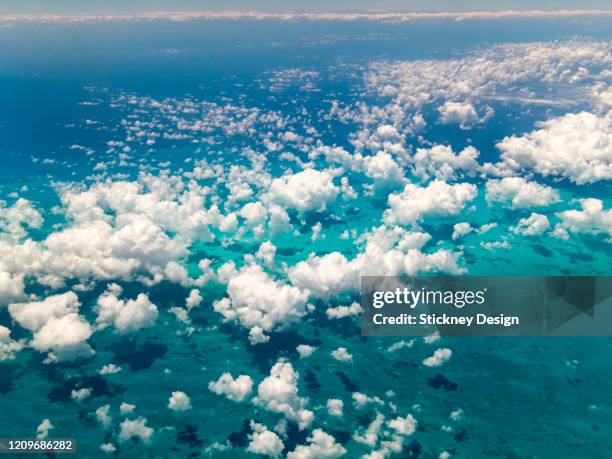 tropical landscape and clouds from plane window - plane in sky stock-fotos und bilder
