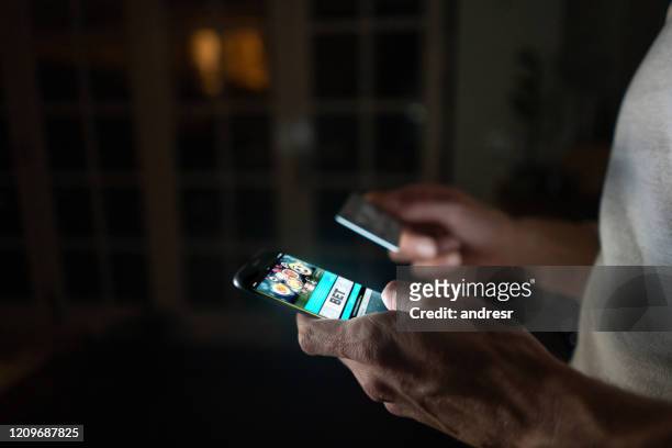 mens die online thuis op zijn celtelefoon zet - verslaving stockfoto's en -beelden