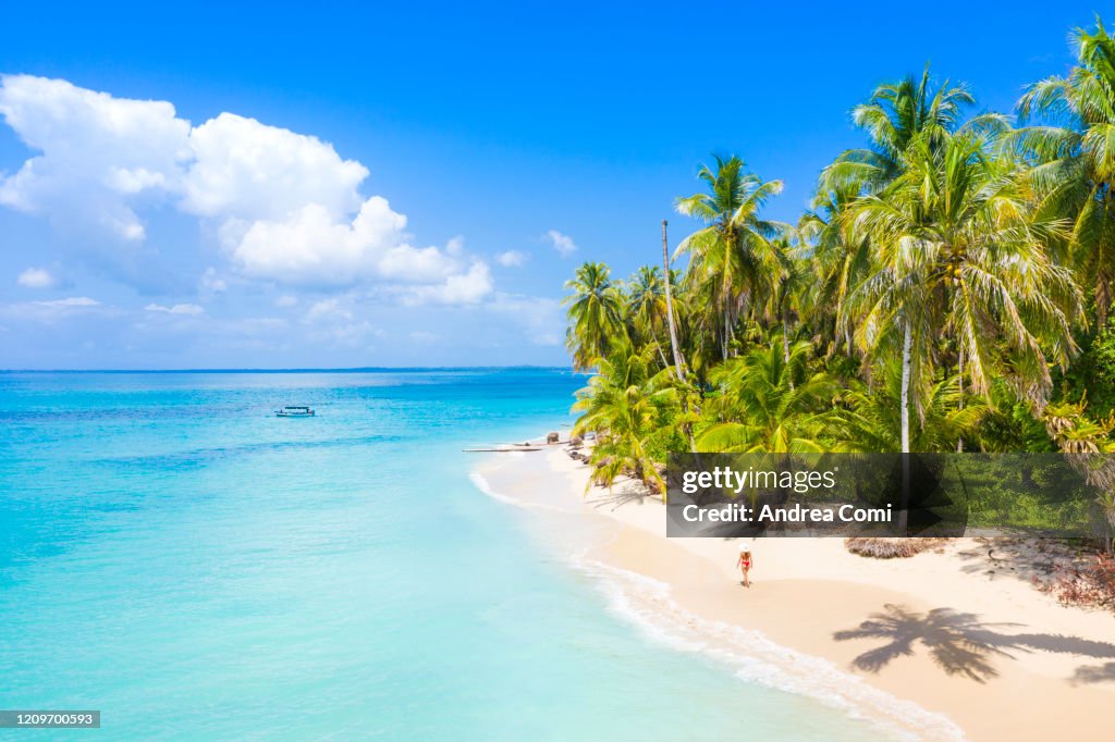 Young woman walking on a desert tropical beach. Zapatilla island, Panama