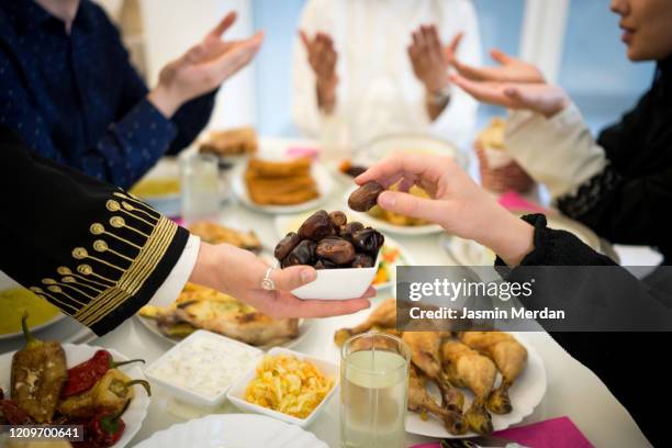 ramadan happiness - breaking fasting and praying together - iftar photos et images de collection