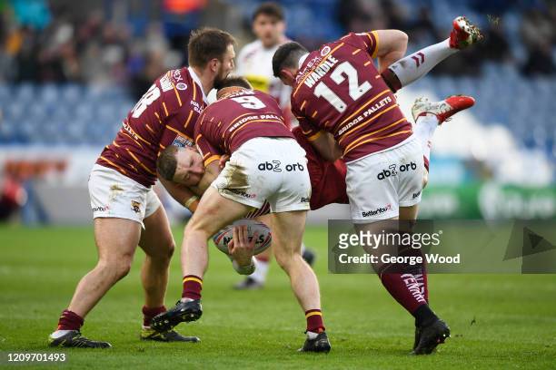 Jackson Hastings of Wigan Warriors is tackled by the Huddersfield Giants defence during the Betfred Super League match between Huddersfield Giants...