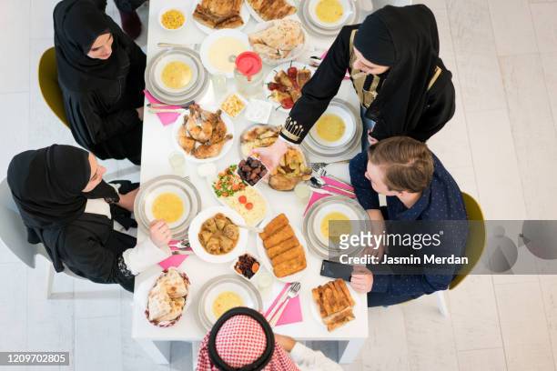 muslim family eating iftar together - saudi lunch stock pictures, royalty-free photos & images