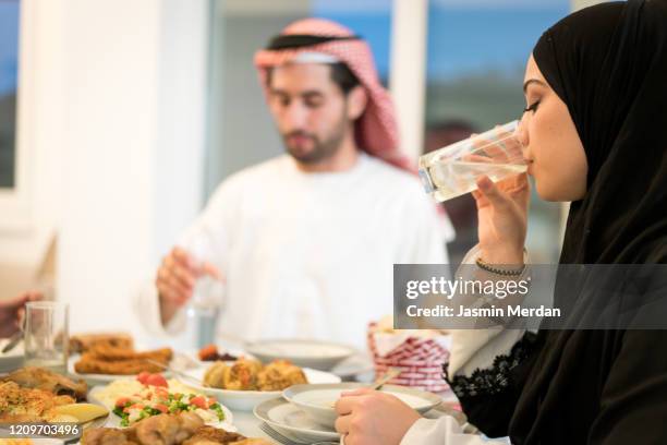 muslim couple drinking water for breaking ramadan fasting - saudi lunch stock pictures, royalty-free photos & images