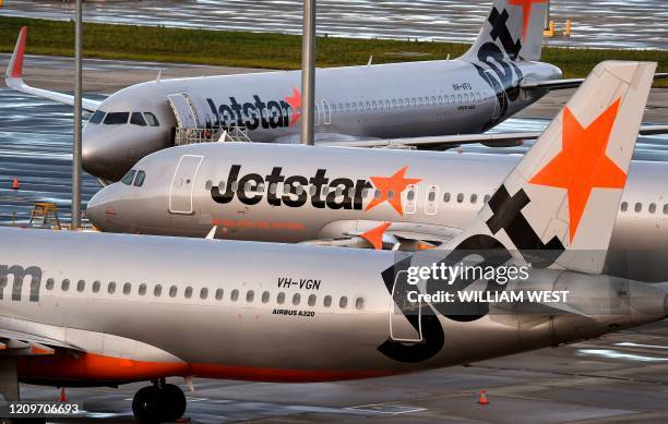 Australian airline Jetstar planes sit idle on the tarmac at Melbourne's Tullamarine Airport on April 12, 2020. - Confinement measures taken around...