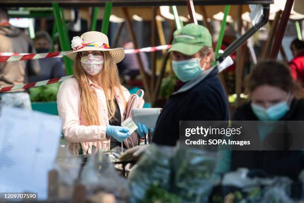 Woman wearing a face mask as a preventive measure against the spread of coronavirus buys fresh vegetables at a market in Maribor. Due to the spread...