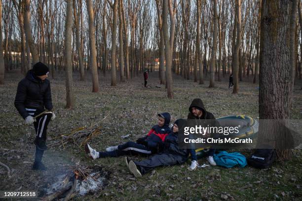 Migrants from Algeria and Morocco sit on their rubber boat that they hope to cross the Evros River from Turkey to Greece with on March 01, 2020 in...