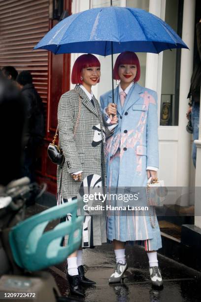 Ami Suzuki and Aya Suzuki of Amiaya wearing Thom Browne outside Thom Browne during Paris Fashion Week Womenswear Fall/Winter 2020/2021 Day Seven on...