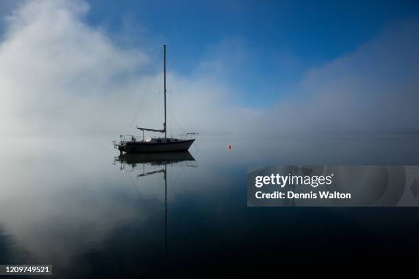 a sailboat and reflection creates a tranquil scene in the calm waters of lake whatcom in bellingham washington - lake whatcom bildbanksfoton och bilder