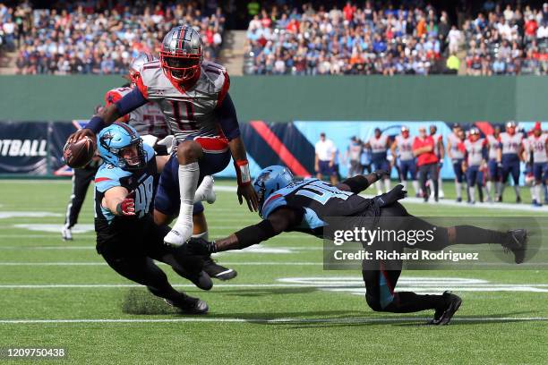 Walker of the Houston Roughnecks leaps between Greer Martini of the Dallas Renegades and Tegray Scales of the Dallas Renegades for a three-point...