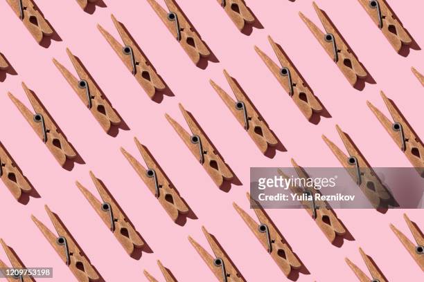 repeated old clothespins on pink background - clothes peg fotografías e imágenes de stock