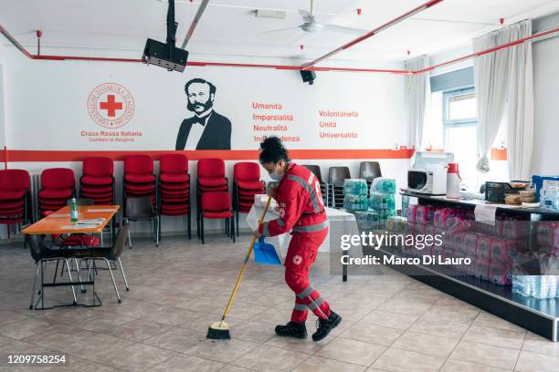 Emanuela Ritota, crew member of an Italian Red Cross ambulance, sweeps the floor of a common area while waiting for an emergency call on April 8,...