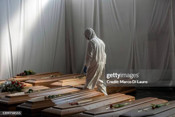 Civil Protection member is seen in the hangar where 18 coffins of victims of COVID-19 wait to be transported to Florence by the Italian Army to be...