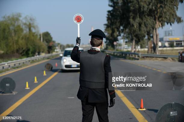 Carabiniere stops a driver during a Carabinieri checkpoint on main roads to check that government restrictions are followed by citizens in order to...