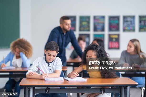 studenten werken samen in een klaslokaal omgeving - brugklas stockfoto's en -beelden