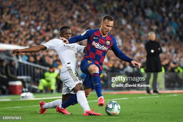 Arthur Melo of FC Barcelona competes for the ball with Vinicius JR of Real Madrid CF during the Liga match between Real Madrid CF and FC Barcelona at...