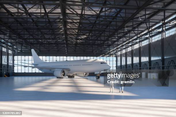 geschäftspaar im flugzeughangar - airplane hangar stock-fotos und bilder