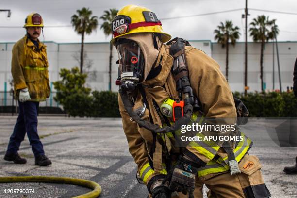Cameron Richards, a probationary firefighter wears a gas mask in a morning training session of the LAFD Station No9 team at Skid Row on April 12,...