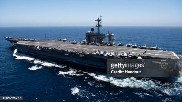 In this handout released by the U.S. Navy, The aircraft carrier USS Theodore Roosevelt transits the Pacific Ocean. Theodore Roosevelt is conducting...