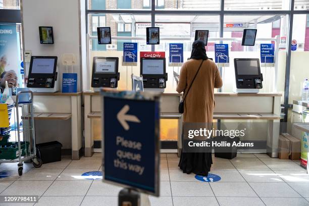 Woman uses a self-checkout at a Tesco on April 13, 2020 in East London, United Kingdom. The Coronavirus pandemic has spread to many countries across...