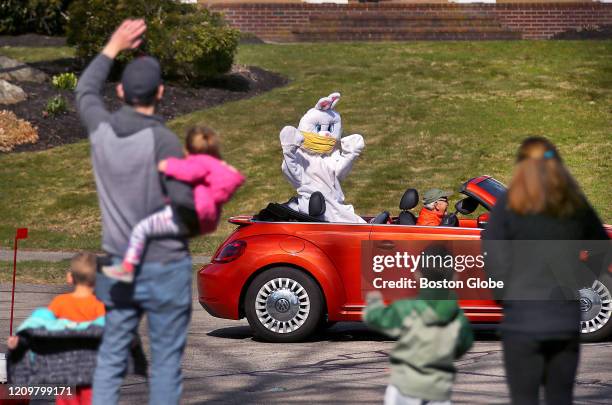 Francoise Elise, dressed up as The Easter Bunny, waves to a family on their front steps on Easter, April 12, 2020 in Milford, MA. Elise was driven...