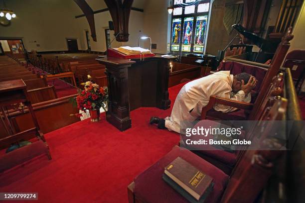 The Rev. Dr. Gregory G. Groover, Sr., Pastor, The Historic Charles Street A.M.E. Church in Roxbury, prays at the church in Boston on April 10, 2020....